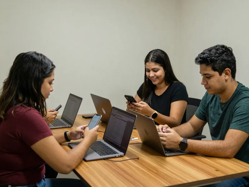 Equipe pequena de vendas olhando os celulares